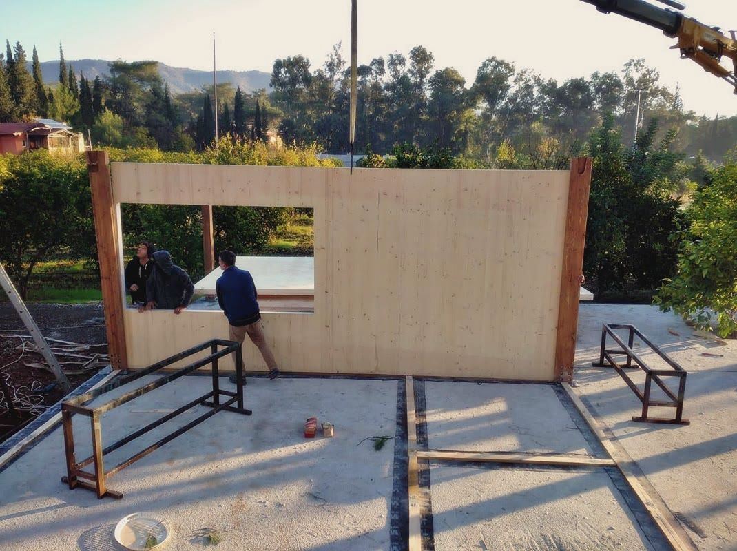 Beton plak üzerinde dikilen masif ahşap panel duvar, pencere boşluğu ve çelik destek çerçeveleri
